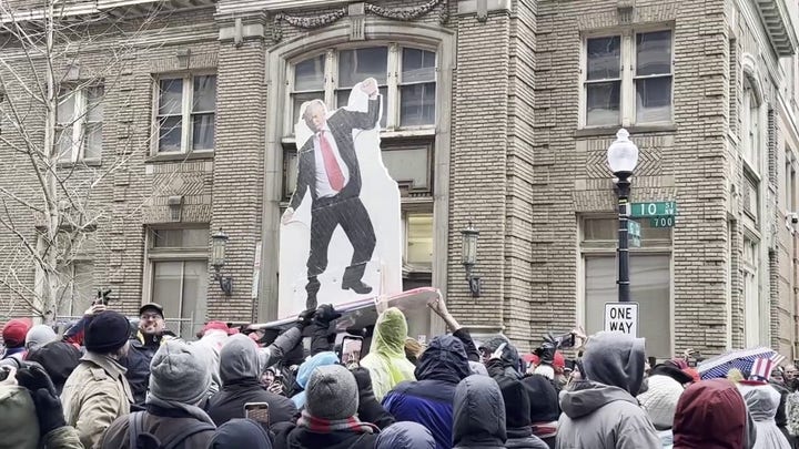 A cardboard cutout of President-elect Donald Trump crowd surfs at a pre-inauguration rally